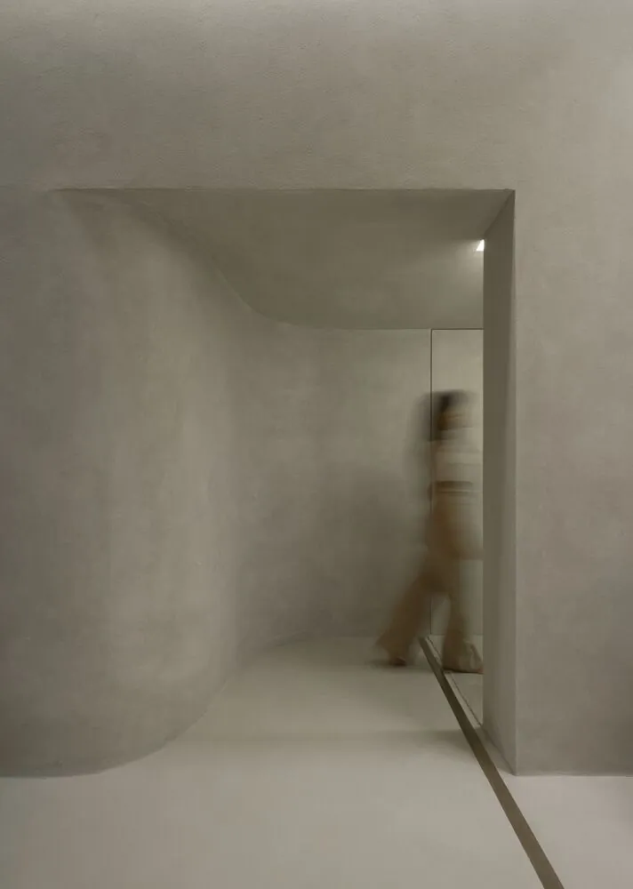 A quiet plaster hallway at an XS office