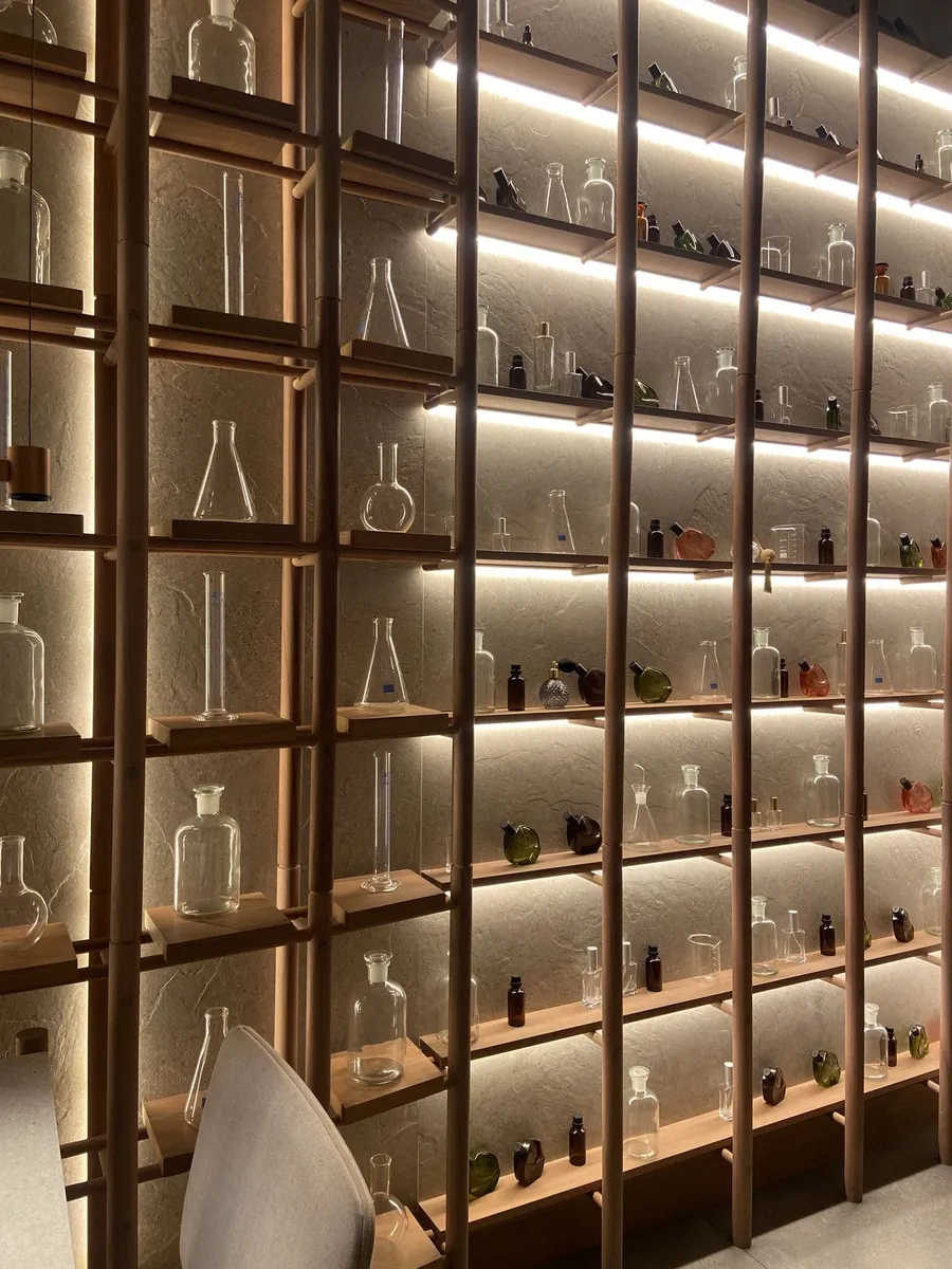 Lab glassware on lit wooden shelves